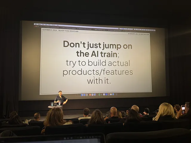 Speaker stands in front of the audience, and the screen behind him reads “Don’t just jump on the AI train: try to build actual products / features with it”